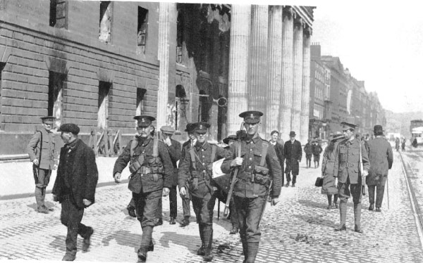 Three Fusiliers pass the burnt out General Post Office